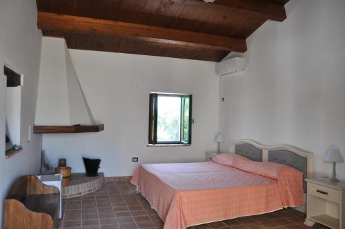a bedroom with a bed and a window at Le Macchie in Calopezzati