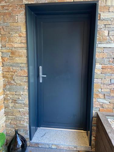 a black garage door on a brick wall at Suite cosy in Chindrieux