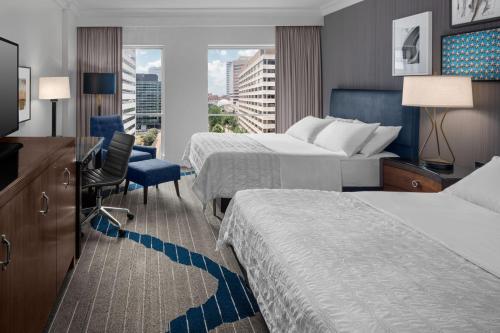 a hotel room with two beds and a desk at Le Meridien Arlington in Arlington