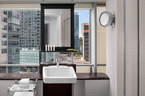 een badkamer met een wastafel en een groot raam bij Le Meridien Arlington in Arlington