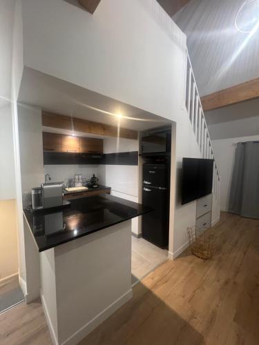 une cuisine avec un comptoir noir et blanc dans l'établissement L’escale proche paris, à Maisons-Alfort