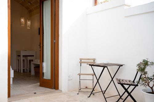 a hallway with a table and a chair next to a door at Oltre gli Ulivi in Ostuni
