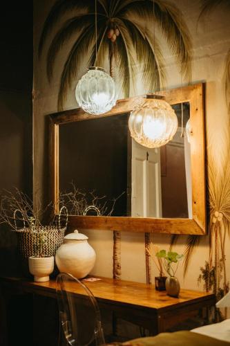 a mirror on a table with two lights at The Hanover Luxury Hotel in Hanover