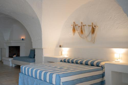 a bedroom with a bed with a blue and white stripes at Oltre gli Ulivi in Ostuni