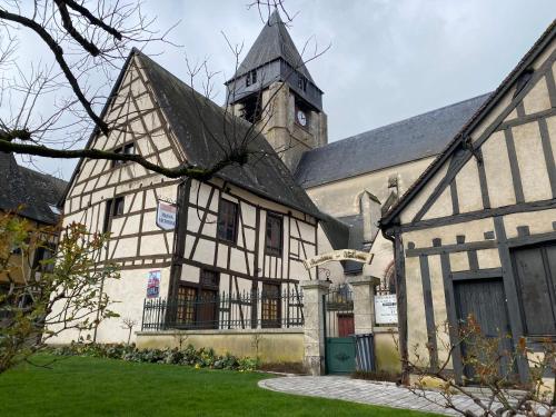 un antiguo edificio con una torre y una iglesia en Charmant studio sous combles, en Aubigny-sur-Nère
