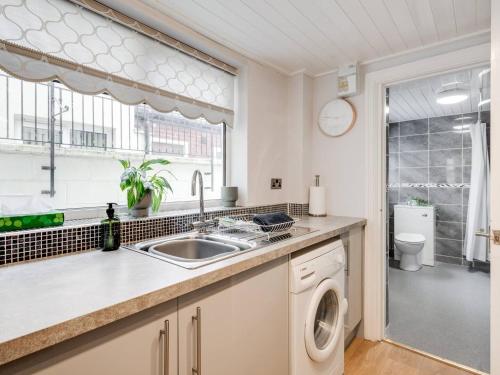 a kitchen with a sink and a washing machine at Pass the Keys Tranquil Green Retreat - 3 Bed Tuebrook Terrace in Liverpool