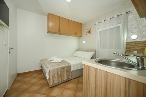 Baño pequeño con cama y lavabo en Vila lux Rajović, en Budva