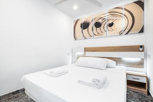 a bedroom with a white bed and a painting on the wall at Las Damas 23-C Levante Beach in Benidorm