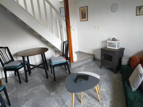 a living room with chairs and a table and stairs at Chambre d'hôtes Se Sentir Libre Noisette in Crozant