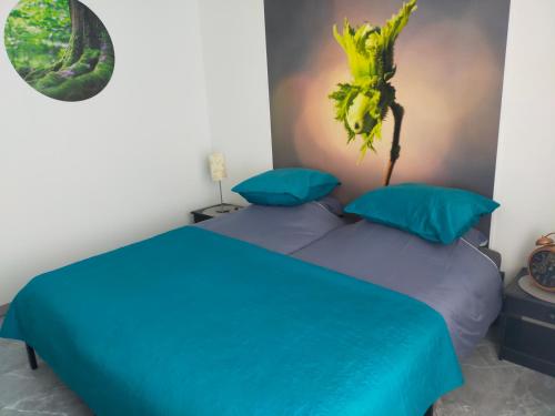 a bedroom with two blue beds and a plant on the wall at Chambre d'hôtes Se Sentir Libre Noisette in Crozant