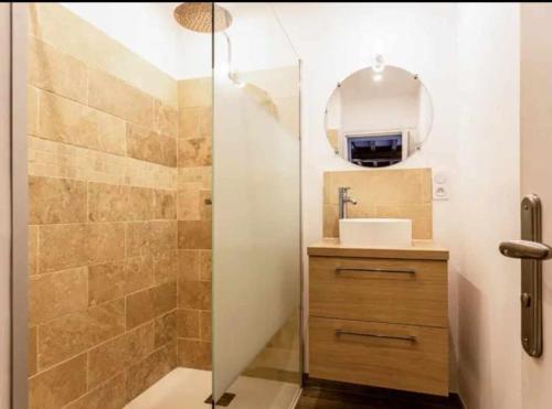 une salle de bain avec une douche avec un lavabo et un miroir dans l'établissement Gite LE CLOS RENARD, à Commes