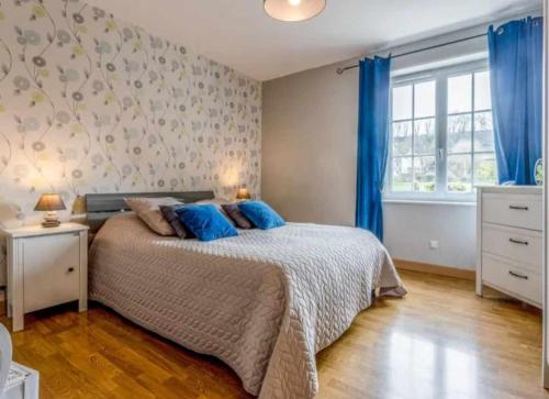 une chambre avec un lit avec des oreillers bleus dessus dans l'établissement Gite LE CLOS RENARD, à Commes