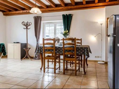 une salle à manger avec une table et quelques chaises dans l'établissement Gite LE CLOS RENARD, à Commes