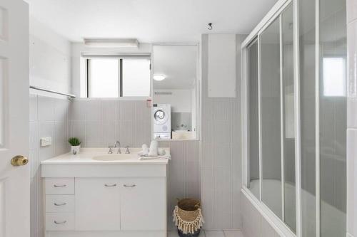 a white bathroom with a sink and a shower at Penthouse in Gold Coast in Gold Coast