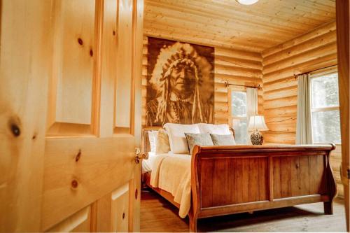 een slaapkamer met een bed in een houten hut bij Chalet Authentik 27 - Hot tub, Pools, Lake & Resort in Mille-Isles