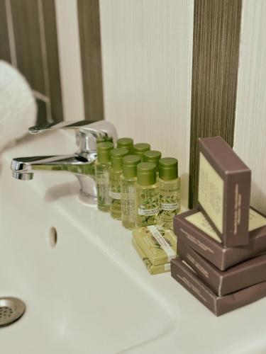 a bathroom sink with four bottles of essential oils and a box at Appartement Cosy - Proche Dysneyland - Paris - RER in Noisy-le-Grand