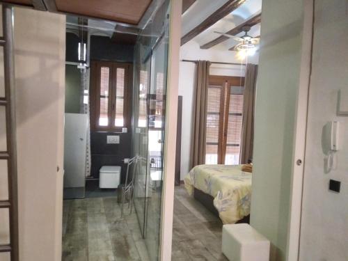 een slaapkamer met een bed en een glazen deur naar een badkamer bij Valencia Centro Suite in Valencia