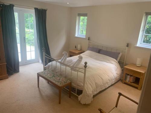 um quarto com uma cama, um banco e janelas em Relaxing country cottage bungalow em Yaxley