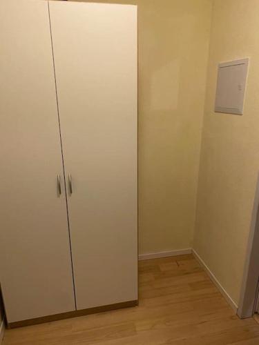 um armário branco num quarto com piso de madeira em Privatunterkunft in Wuppertal em Wuppertal