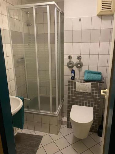 uma casa de banho com um chuveiro, um WC e um lavatório. em Privatunterkunft in Wuppertal em Wuppertal