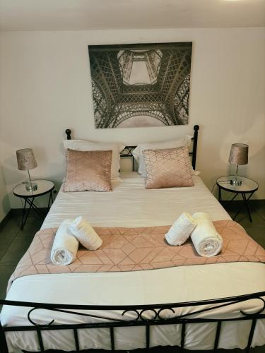 a large bed with three pillows on top of it at Appartement Cosy - Proche Dysneyland - Paris - RER in Noisy-le-Grand