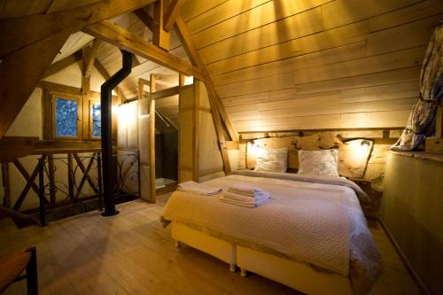 a bedroom with a large bed in a wooden room at Gîte La Maisonnette La Petite Joulinie in Bor-et-Bar
