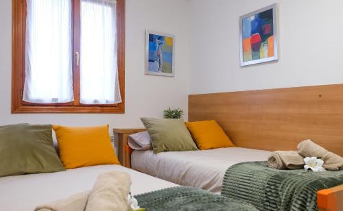 Habitación con 2 camas con almohadas amarillas y verdes en APARTAMETO BAZTANGOA I, en Elizondo