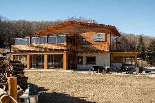 una gran casa de madera con muchas ventanas en Campaegli resort, en Campaegli