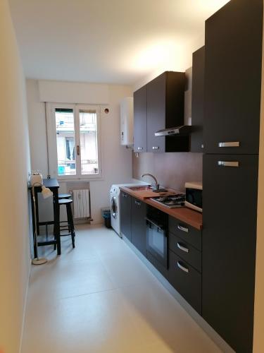 a kitchen with black cabinets and a white floor at Frank's studio rooms in Padova