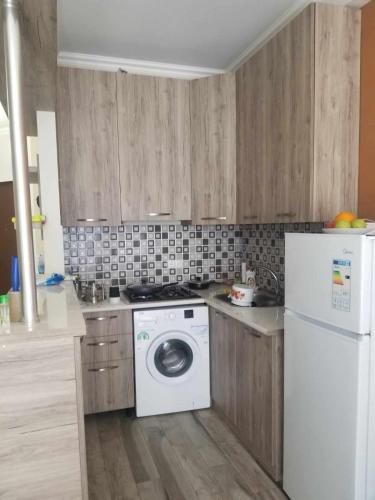 een keuken met een witte koelkast en een wasmachine bij Apartament 300 in Tbilisi City