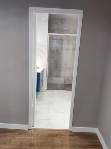 une porte ouverte menant à une chambre dotée d'un sol blanc dans l'établissement Maison plein pied à Livry G., à Livry-Gargan