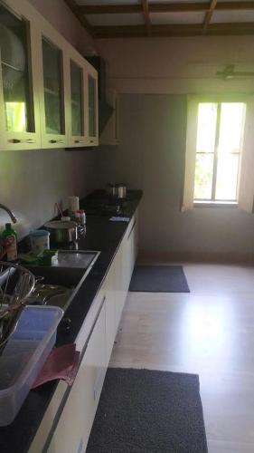 a kitchen with a sink and a counter top at Kaanayi Heritage Home in Payyannūr