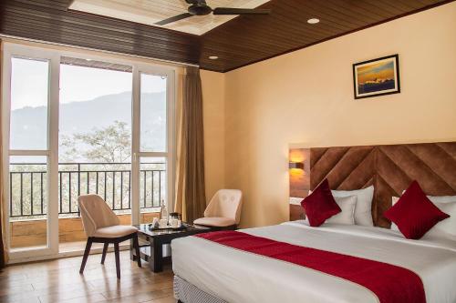 a hotel room with a bed and a balcony at The Pahuna Retreat in Gangtok