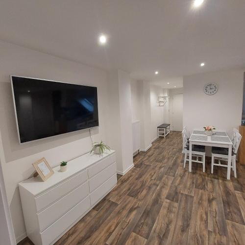 a living room with a dining table and a large flat screen tv at Apartmán Milan in Česká Třebová