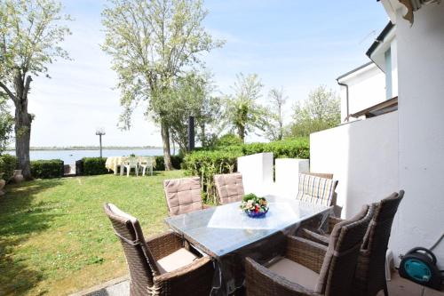 a table and chairs on a patio with a view of the water at Villa Fortuna in Palazzo Vianello