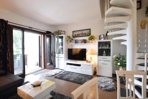 a living room with a staircase and a television at Villa Fortuna in Palazzo Vianello