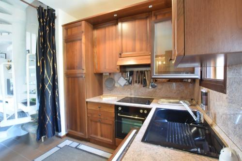 a kitchen with wooden cabinets and a stove at Villa Fortuna in Palazzo Vianello