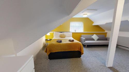 a bedroom with yellow walls and a bed and a couch at Central Stunning 3-Bed House - Free Parking in Sunderland