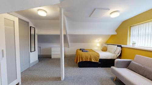 a bedroom with a bed and a couch in a room at Stunning City Centre 2024 Refurb in Sunderland