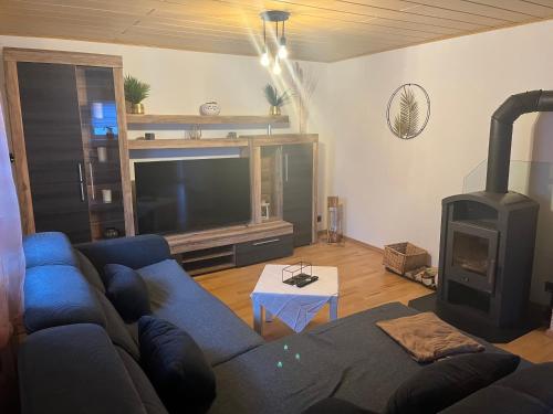 a living room with a blue couch and a wood stove at Jenny‘s FeWo in Idar-Oberstein