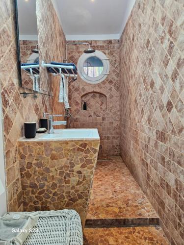 a bathroom with a stone shower with a sink at Guest house calme avec accès jardin et piscine in Flayosc