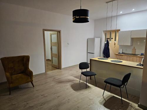 a kitchen with two chairs and a table and a counter at Apartament w Centrum Kalisza in Kalisz