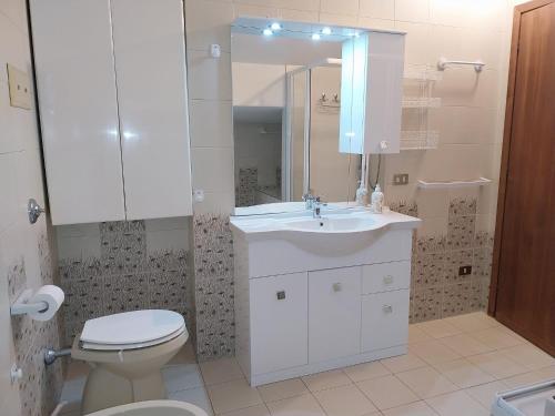 bagno con lavandino, servizi igienici e specchio di Bellavista garden and flowers a Varenna