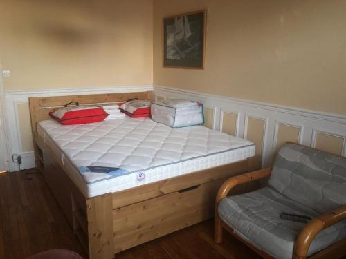 Bett in einem Zimmer neben einem Stuhl in der Unterkunft Charmant Appartement 3 chambres - JO Paris 2024 in Colombes