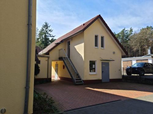 a house with a staircase on the side of it at Ferienwohnung Prälank direkt am See in Neustrelitz
