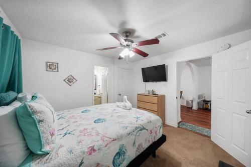Schlafzimmer mit einem Bett und einem Deckenventilator in der Unterkunft Galveston Beach House Family/Pet Friendly in Galveston