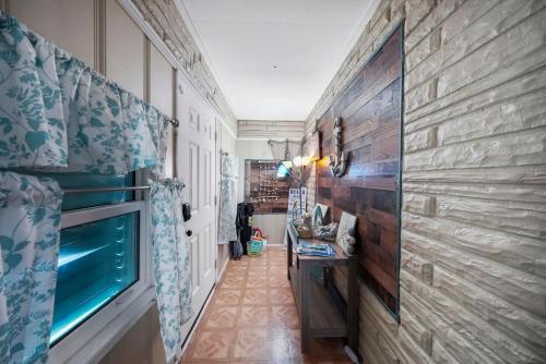 a hallway with a stone wall and a television at Galveston Beach House Family/Pet Friendly in Galveston