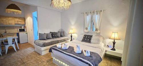 - un salon avec deux lits et un canapé dans l'établissement Pleasure Seaside Rooms, à Perissa