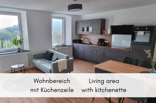 a kitchen and living area with a couch and a table at Terrasse der Ruhe im Alten Winzerhaus am Calmont in Bremm