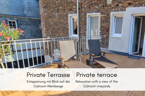 a pair of chairs sitting on a balcony at Terrassenidylle in Winzerhaus in Bremm